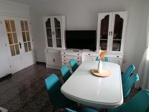a dining room with a white table and blue chairs at Casa el moral 2 in Castillejo de Martín Viejo