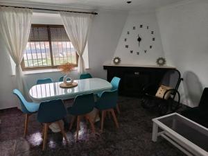 a dining room with a table and chairs and a clock on the wall at Casa el moral 2 in Castillejo de Martín Viejo