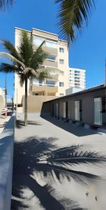 a building with palm trees in front of it at Cantinho Charmoso Pertinho do Mar in Navegantes