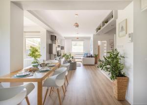 a dining room and living room with a table and chairs at Riverside Apartman**** Miskolc in Miskolc