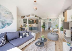 a living room and kitchen with a blue couch at Riverside Apartman**** Miskolc in Miskolc