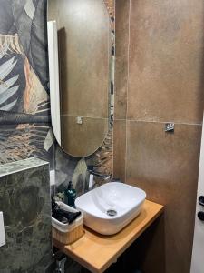 a bathroom with a white sink and a mirror at Liams Cozy Villa in Korçë