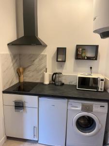 a kitchen with a washing machine and a microwave at Cocon de Tonnerre in Tonnerre