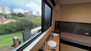 a bathroom with a sink and a large window at Studio 48 - Lindo apto Studio no centro de Foz in Foz do Iguaçu