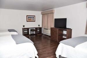 a hotel room with two beds and a television at Eagle Peak Lodge & Cabins in Ashton