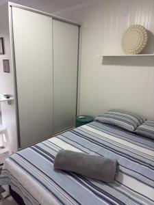 a bedroom with a bed with a towel on it at Refúgio ensolarado a poucos passos do mar in Navegantes