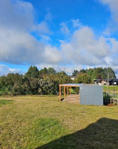a pavilion in a field with trees in the background at Tiny House en parcela de Puerto Varas in Puerto Varas +1 photo