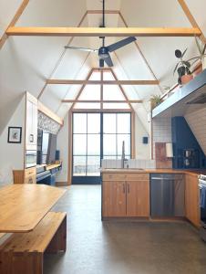 a large kitchen with wooden cabinets and a large window at Cedar Peak - Design-Forward Barrier-Free Chalet in Grand-Etang