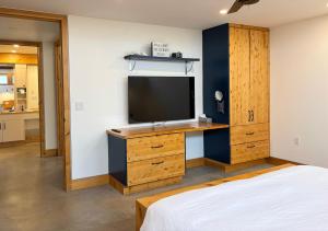 a bedroom with a tv and a desk with a bed at Cedar Peak - Design-Forward Barrier-Free Chalet in Grand-Etang