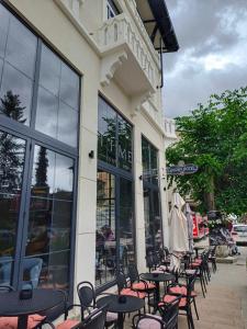 a group of tables and chairs in front of a building at Golden Guesthouse in Resen