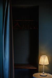 a table with a lamp in a room with a curtain at Liiiving in Azores - Ocean View House in Canto da Areia