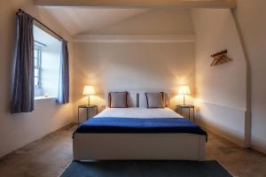 a bedroom with a large bed with two lamps at Liiiving in Azores - Ocean View House in Canto da Areia +23 photos