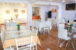 a dining room with white tables and white chairs at Hotel Paola Antofagasta in Antofagasta