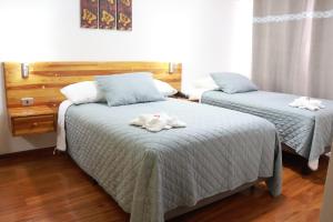 a bedroom with two beds with towels on them at Hotel Paola Antofagasta in Antofagasta +28 photos