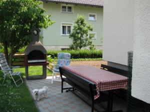 a patio with a table and a grill and a dog at Apartment Marinka in Bled +6 photos
