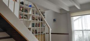 a book shelf with books on it next to a staircase at Kingfisher Cottage Wales in Llanidloes