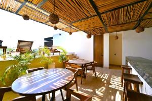 two tables and chairs in a room with plants at Swim up pool Beachclub rooftop in Tulum