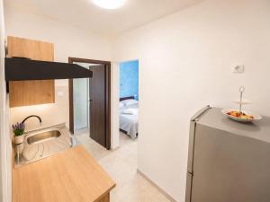 a kitchen with a sink and a refrigerator at Ap AS in Rogoznica