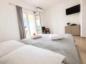 two beds in a bedroom with a large window at Ap AS in Rogoznica