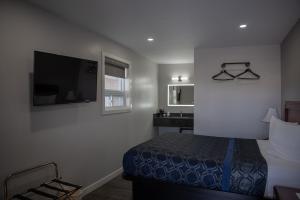 a hotel room with a bed and a sink at Aquarius Motel in Perth