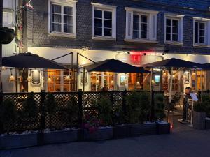 a restaurant with umbrellas in front of a building at EVIA Hotel restaurant in Recklinghausen