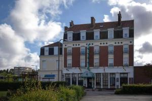 a large building with a red and white at Metropol Hotel in Calais