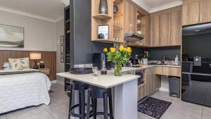 a kitchen with a bed and a table with flowers on it at Studio Bella Vista Plett in Plettenberg Bay