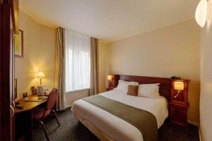 a hotel room with a large bed and a desk at Metropol Hotel in Calais