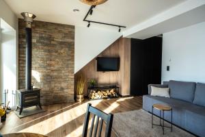 a living room with a blue couch and a fireplace at Apartamenty Fuleda nad jeziorem Dobskim Mazury Holiday in Fuleda