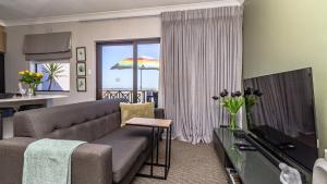 a living room with a couch and a view of the ocean at Studio Bella Vista Plett in Plettenberg Bay