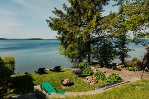 a park with a fire pit and a lake at Apartamenty Fuleda nad jeziorem Dobskim Mazury Holiday in Fuleda +11 photos