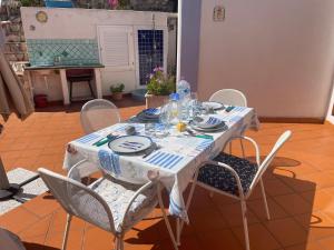 a table with chairs and a white table cloth at La Vite in Ponza