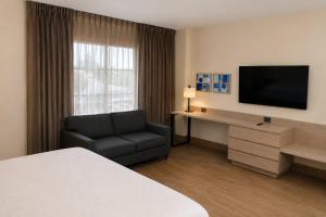 a hotel room with a bed and a tv and a chair at Holiday Inn Express - Monterrey - Tecnologico by IHG in Monterrey