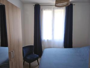 a bedroom with a bed and a chair and a window at Appartements sur l'ile de Porquerolles in Porquerolles