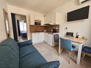 a living room with a couch and a table with a laptop at Appartements sur l'ile de Porquerolles in Porquerolles