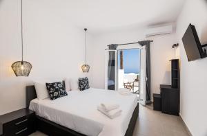 a bedroom with a bed with a view of the ocean at Aurora Sky & Sea in Fira