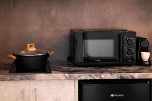 a microwave oven and a pot on a counter at Aurora Sky & Sea in Fira