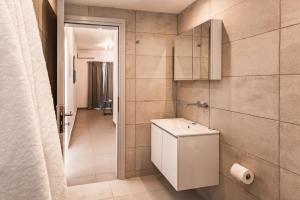 a small bathroom with a toilet and a corridor at Aurora Sky & Sea in Fira +29 photos
