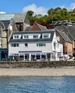 a large white building sitting next to the water at Island View in Oban