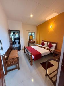 a bedroom with a large bed and a bathroom at Little England Grand Hotel in Nuwara Eliya