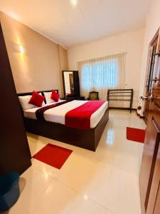 a bedroom with a large bed with red pillows at Little England Grand Hotel in Nuwara Eliya