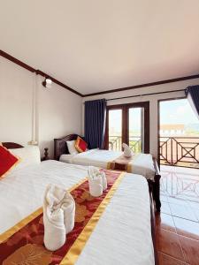 a hotel room with two beds with towels on them at Vangvieng Sisavang Mountain View Hotel in Vang Vieng +114 photos