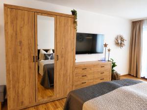 a bedroom with a large wooden cabinet with a mirror at Forest Apartment Gosau in Gosau +62 photos