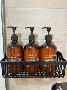 three bottles of shampoo and body wash on a shelf at Drama Homes Argiroudi in Drama