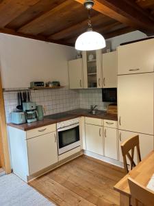 a kitchen with white appliances and a wooden table at Ferienwohnung Gaiswinkler in Grundlsee