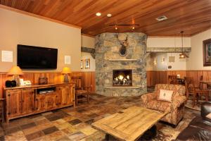 a living room with a stone fireplace and a tv at Jackpine & Black Bear Condos by Vail Resorts in Keystone