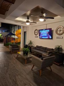 a living room with couches and a tv on a wall at MarySol Las Palmas in Rincon de Guayabitos