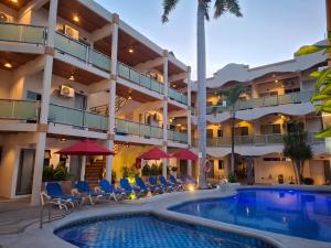 a hotel with a swimming pool in front of a building at MarySol Las Palmas in Rincon de Guayabitos
