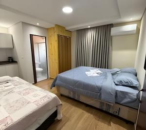 a bedroom with a bed and a bathroom with a tub at Joseph Prime Studio Hotel Extrema MG in Extrema
