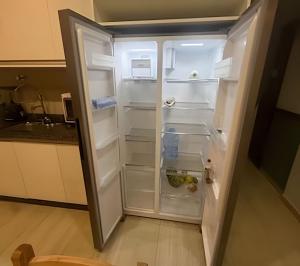 an empty refrigerator with its door open in a kitchen at Joseph Prime Studio Hotel Extrema MG in Extrema